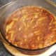 Bhuna sauce is poured over chicken legs in casserole dish