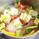 Bell peppers, onion, celery and seasoning are added to pot