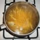While meat mixture is simmering, bring 6 cups of water to a boil. Add spaghetti or angel hair pasta to boiling water.