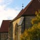 Shooting against a bright sky, I chose to under-expose and make the white balance warmer to capture the golds and red of the church roof. Quedlinburg, Germany.