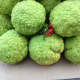 Hot glue holly and berries in gaps of Hedge Apples