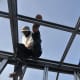 The roofmen at work fixing the frames solidly to the base.