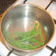 Trimmed grean beans are blanched in simmering, salted water