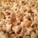 Put your popcorn into a large baking dish. If you are adding peanuts, you'll want to add them at this step.