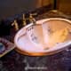 pink bathroom sink with exquisite floral design and gold accents