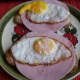 Fried eggs are added to the slices of Graubrot with ham.