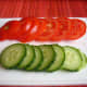 Slices of tomatoes and cucumber for topping.