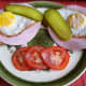 Ready to eat for breakfast. Strammer Max with pickled gherkins and tomatoe slices.