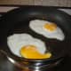 Fried eggs which will be added to slices of Graubrot.