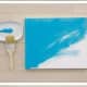 Step 2: Apply a different base coat of paint with the chip brush to each of  the stretched canvases, including the edges.