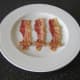 Preparing to wrap cocktail sausages in bacon