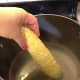 Corn going into the pot to boil for 90 seconds.