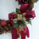 Bow at bottom of wreath. See how the gold beads have formed loops and in the center of the bow holly.