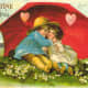Cute kids: little boy and girl under red umbrella with pink hearts