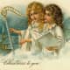 Two vintage Christmas angels floating in the clouds with harp and village in the background