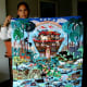 An arpillerista proudly displays her large arpillera of Noah's ark.