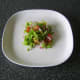 Salad is laid in the centre of a plate