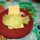 White bread spread with margarine or butter and lettuce on top.