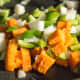 Sweet potato and veggies mixed in the pan.