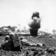 A 6th Marine Division demolition crew watches explosive charges detonate and destroy a Japanese cave, May 1945.