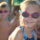 Daughter in the bullpen waiting for race. Her twin is waiting behind her for the next swim race.