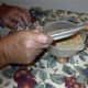 Here Kosta is emptying a freshly inspected plate of wheat into the bowl.