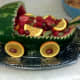 Add orange slices and grapes for the wheels. Fill with fruit and enjoy!