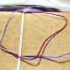 6.  Pass the left blue cord over the right red cord.  Pass the red cord over the beige filler cords and through the blue loop.