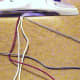 3.  Pass the red cord over the middle beige cords and then through the blue loop.