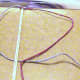 5.  Begin making a left half-knot by taking the left cord which is again blue and passing it under the beige filler cords.