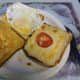 Ingredients, three slices of bread, fried egg and toasted cheese, ready to make the Double Decker Toasted Sandwich