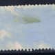 This is the back of a stamp that has been removed from an envelope. There is still a lot of paper attached to the stamp. This is not desirable.