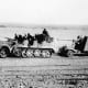 In North Africa, 8.8cm Flak 18 towed behind a Sd.Kfz. 7, with its side outriggers lifted for transport visible behind the gun shield.