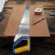 Using a handsaw to cut the facing plate for the rear left speaker