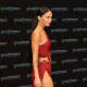 Megan Fox in a revealing dress with a hip high slit up the side wearing platform high heels