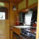 Interior of our Vintage camper with her new boomerang curtains, cutting board fitted to sink &amp; mirror.