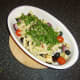 Fusilli pasta and parsley are added to the roasted vegetables