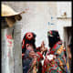 Two Yemeni females in Sana'a city while wearing the Sana'ani Sitarah with its Mughmug and Lithmah
