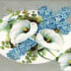 White Easter lilies with forget-me-nots on a hammered silver background