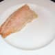 The baked trout fillet is laid on a serving plate.