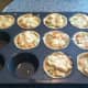 Adding in the chicken mixture to the pastry in the muffin tins