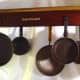 Upcycled hanging pot and pan rack created from antique piano parts