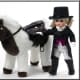 This Madame Alexander Girl is very elegant in her Equestrian long tail black coat, white pants, red vest, white scarf with gold horse shoe charm, black high top boots, and black Top Hat. She comes with a White and Brown plush Horse. 