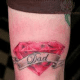 Tattoo of a diamond with "Dad" written in a banner