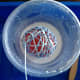 Wrap string around the balloon and then soak the yarn ball in the glue mixture by pressing down on the balloon.