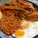 Egg, chips and baked beans with a slice of cheddar cheese; chips cooked in their skins (potato skins).