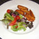 Sweet potato fries are plated with salad bed for tuna
