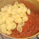 Conchiglie pasta is added to beef and tomato sauce