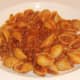 Conchiglie pasta in spicy beef, borlotti bean and tomato sauce is plated