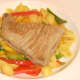 Tuna steak is carefully laid on top of conchiglie and bell peppers